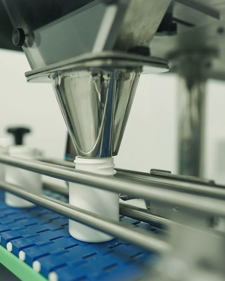 Envasadora llenando botellas en una línea de producción
